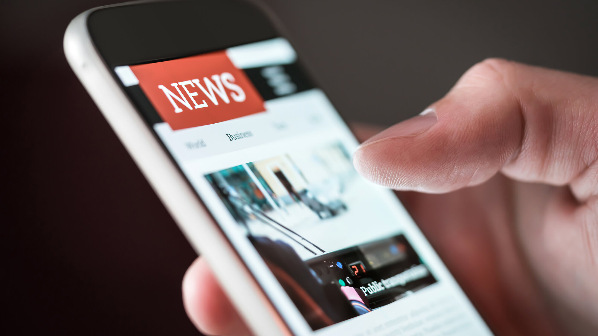 Handy in einer Hand als Nahaufnahme mit dem Wort NEWS